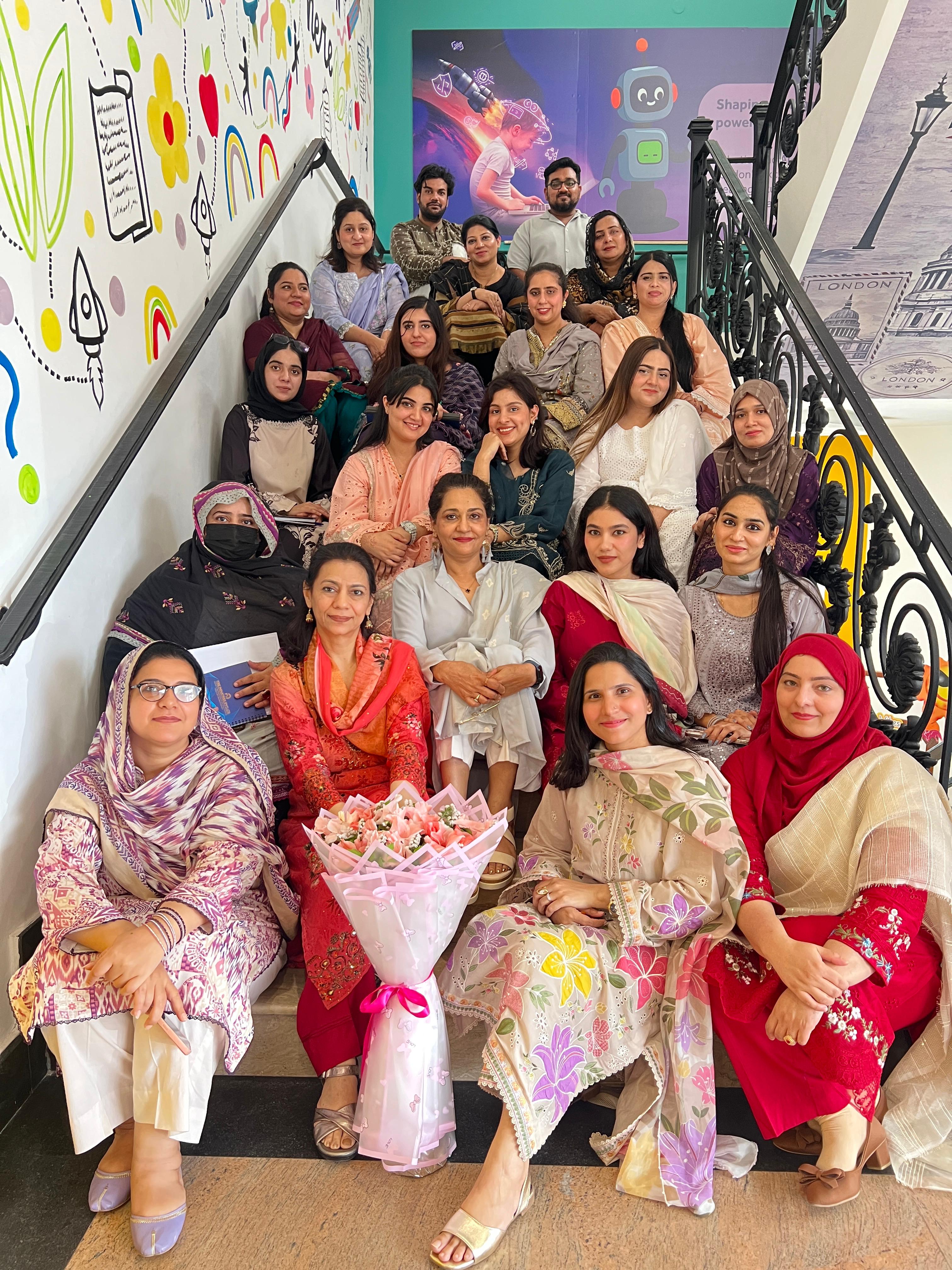 London School full staff team gathered on the staircase