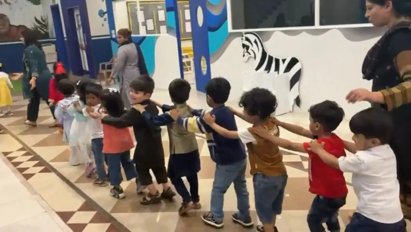 Nursery children walking together through the corridor at London School Lahore