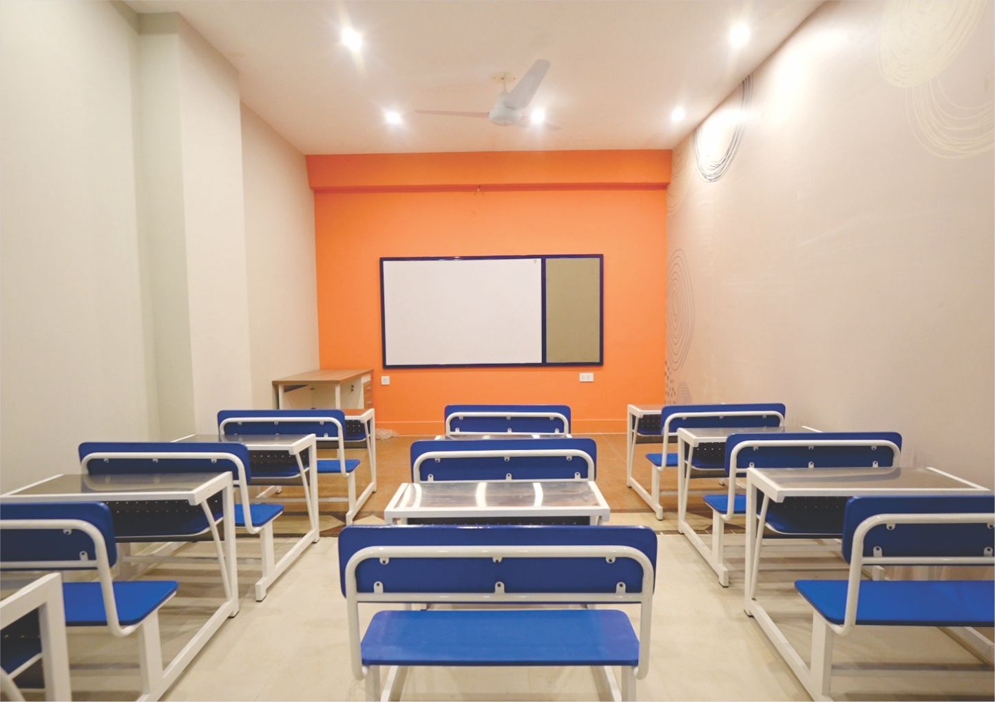Bright classroom with blue desks and orange accent wall